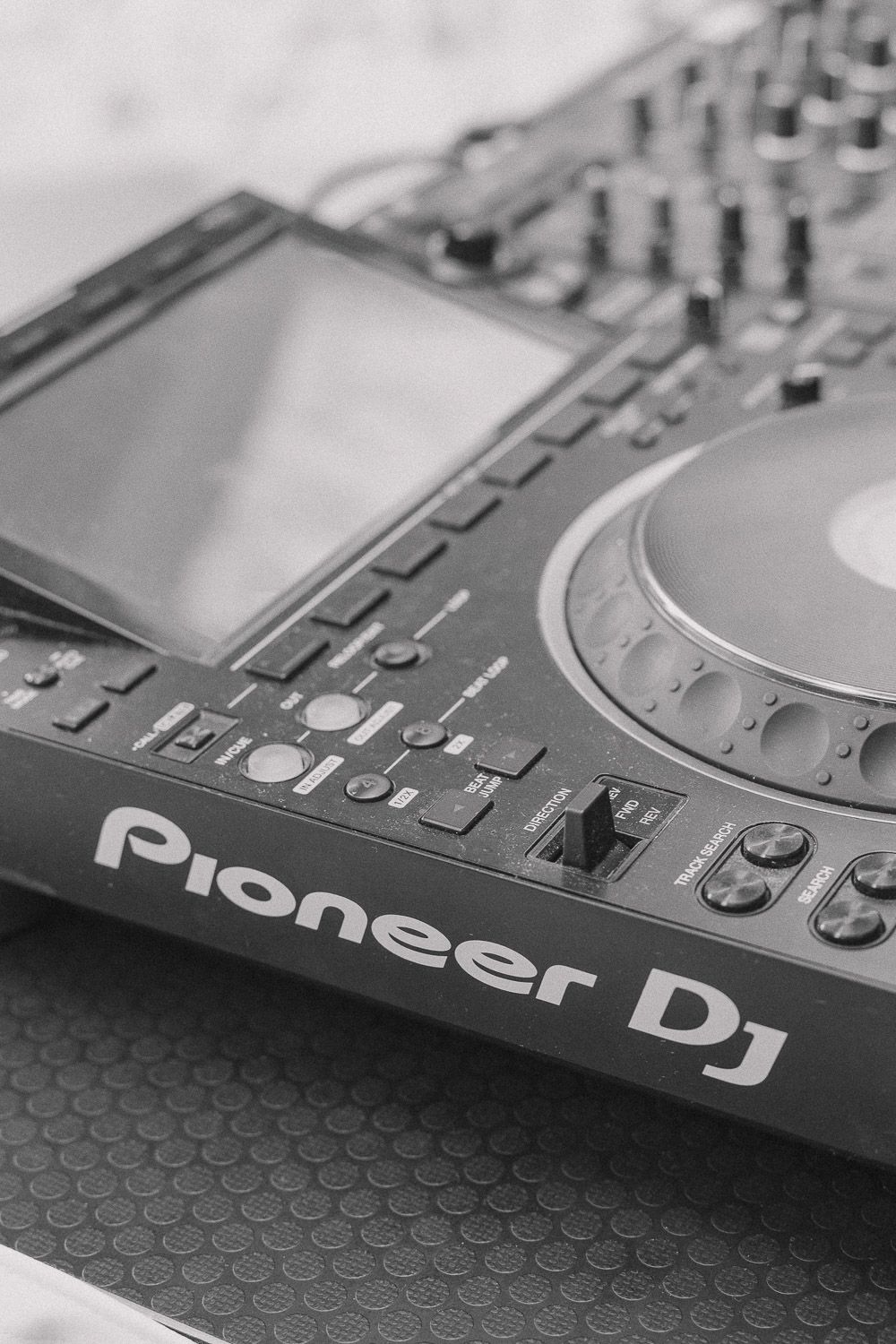 Close-up of a Pioneer DJ controller interface showing LCD screen and control knobs in black and white.