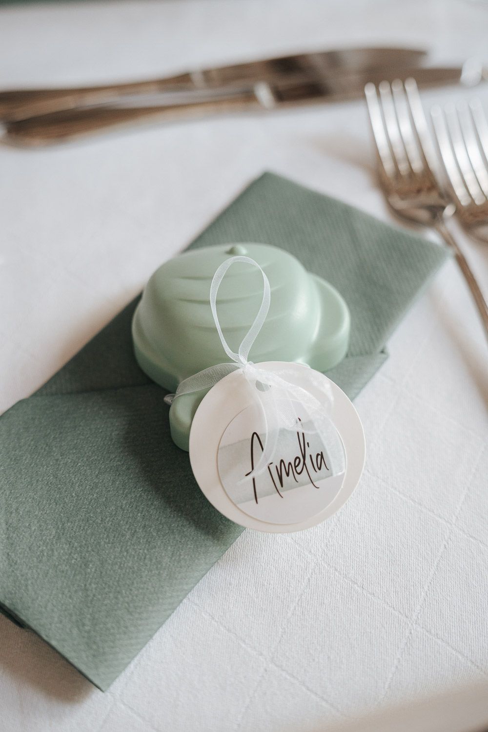 A sequence of five napkin and place setting images showing white menu cards and mint green accents for table decor.