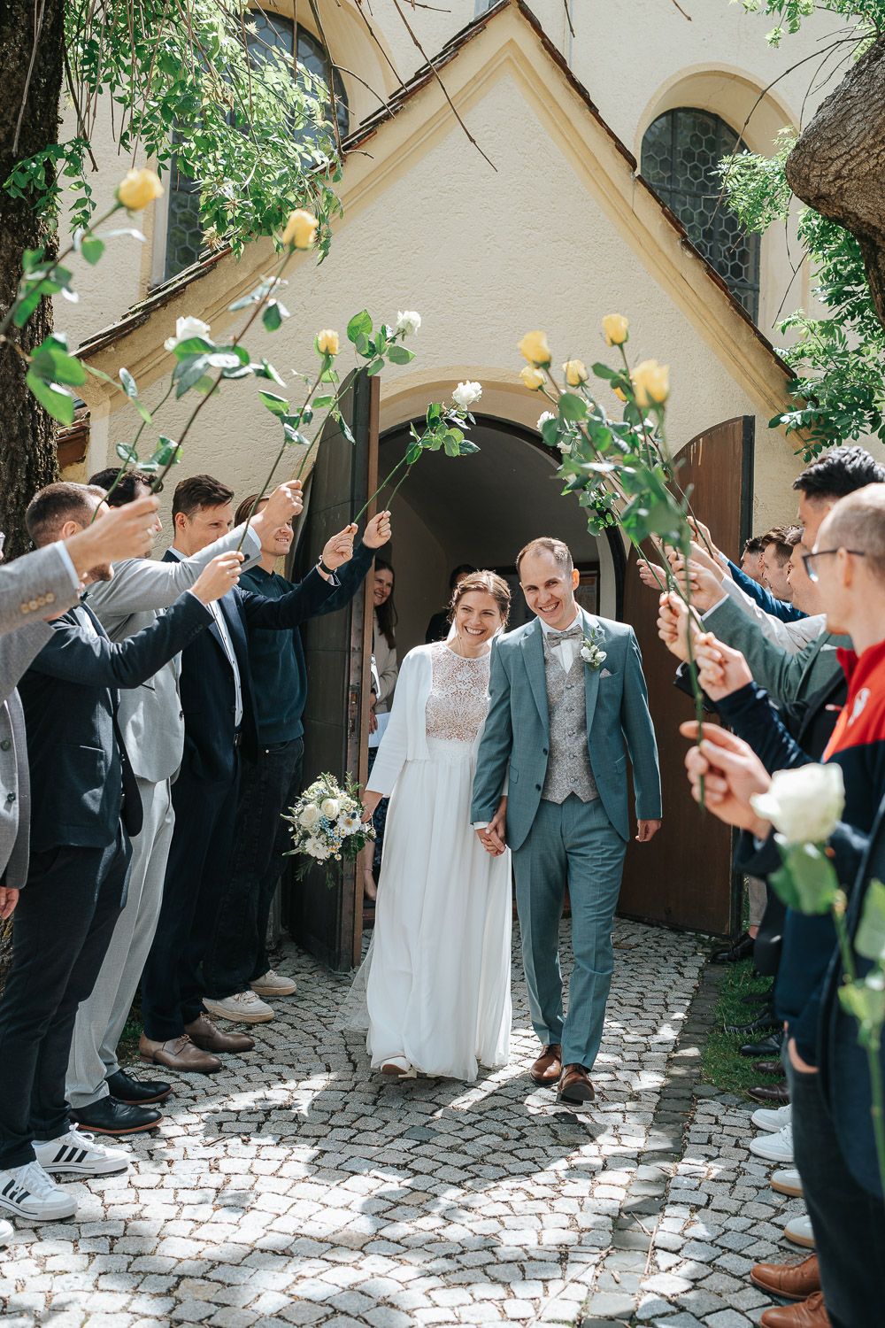 Wedding celebration with guests lined up in a courtyard archway preparing for a traditional rice toss exit celebration.