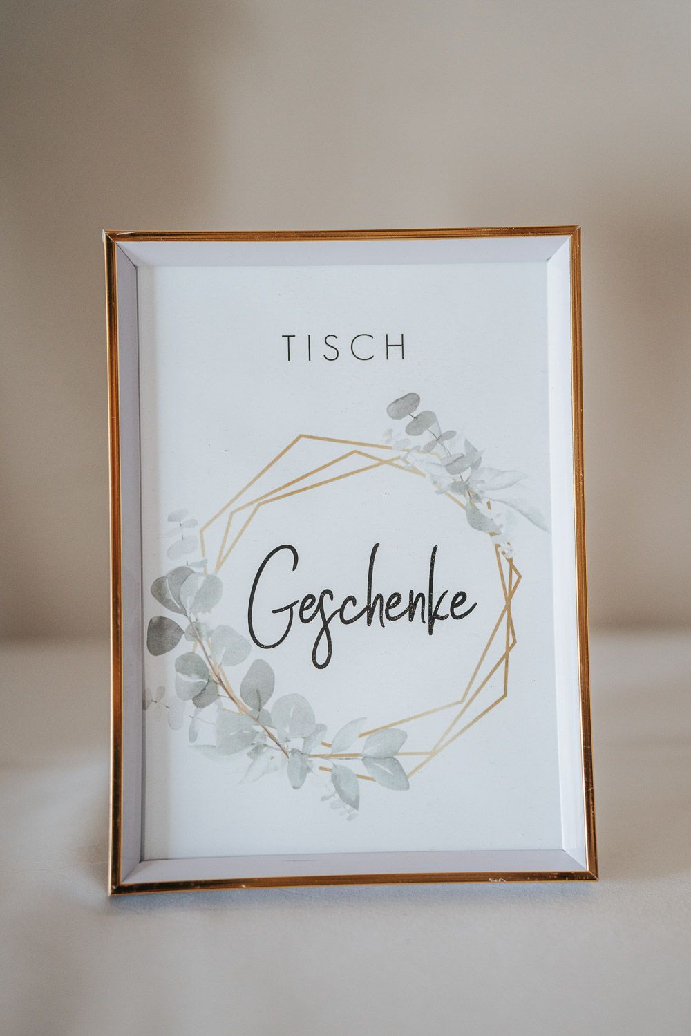 Four minimalist white place cards with elegant gold geometric frames and German text displaying 'Tisch' and 'Geschenke'.