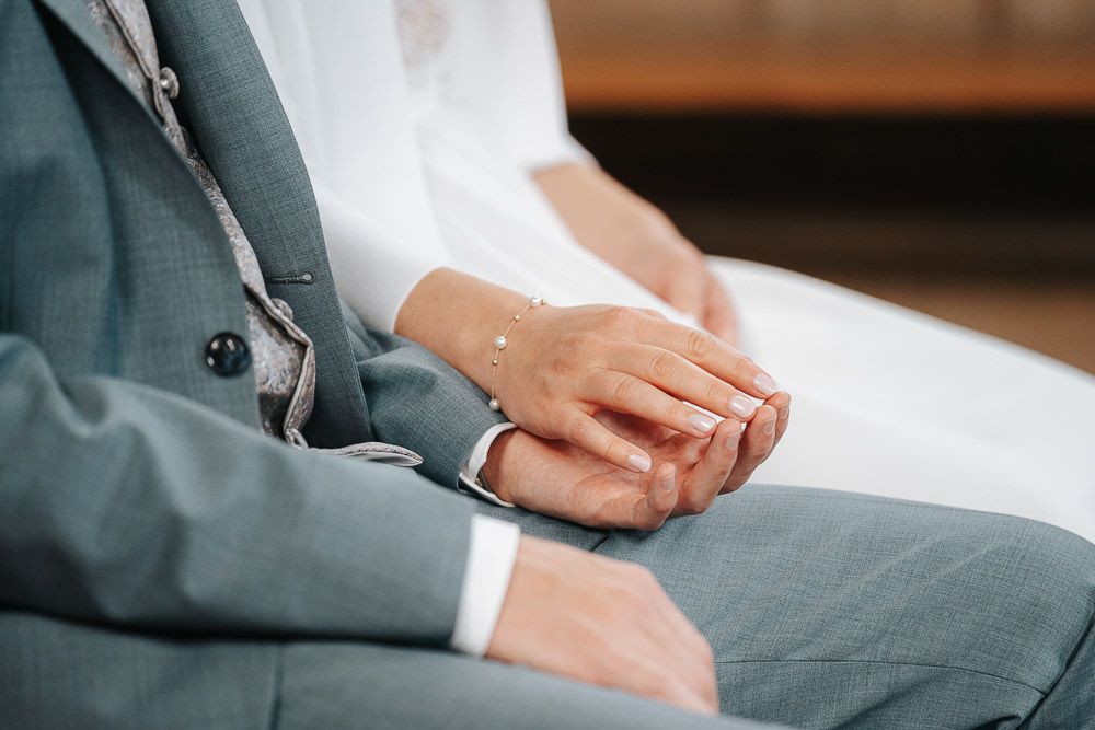 Professional in a grey suit sitting at a table with paperwork and documents spread out during a business meeting.