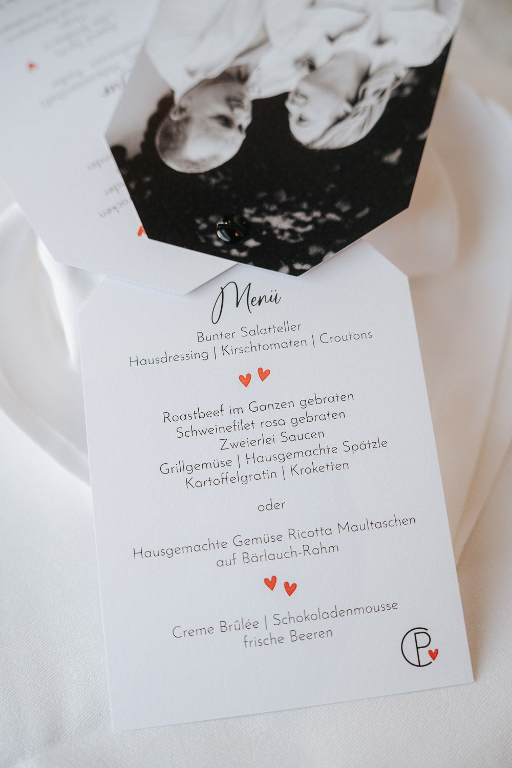Elegant menu card from a wedding reception showing dining options with decorative hearts on white paper.