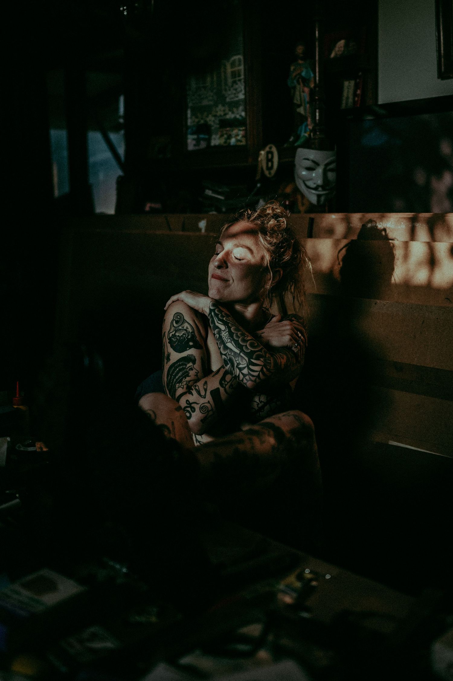 Dramatic indoor portrait with moody lighting and dark background.