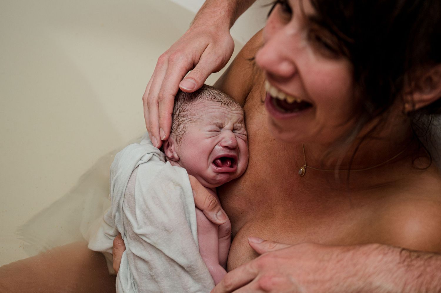 Collage of six intimate moments showing a crying newborn baby being comforted.