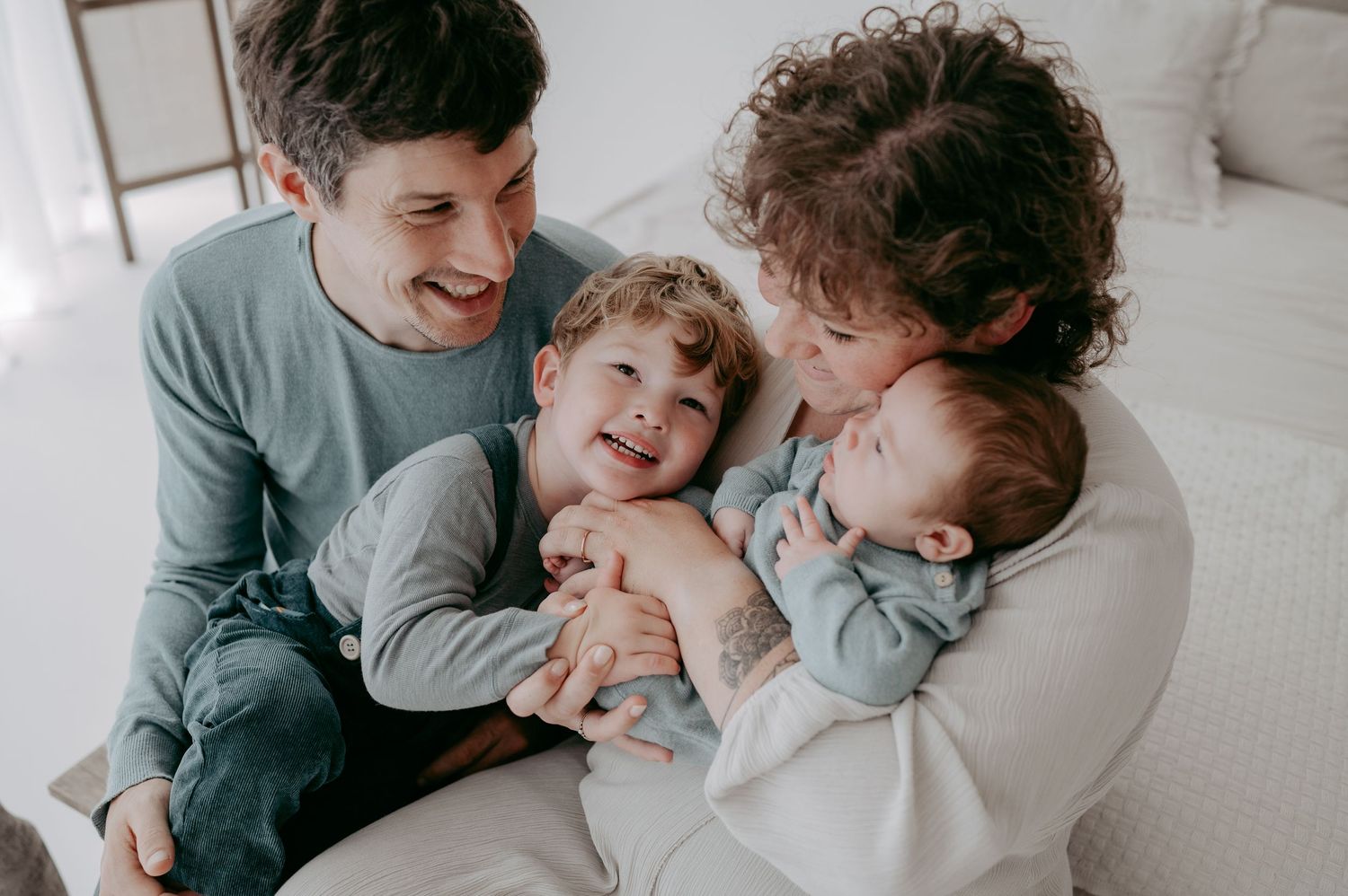 Candid family moment showing joyful interaction on white couch.