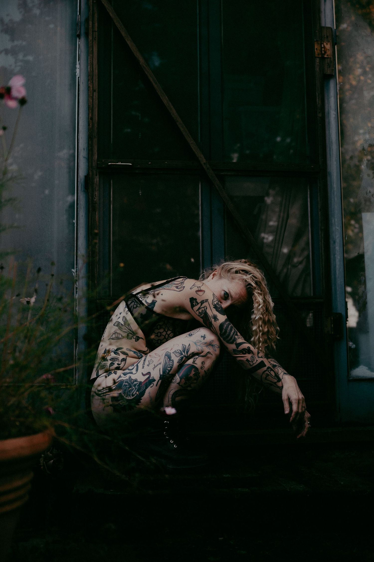 Dark and moody portrait against industrial doorway background.