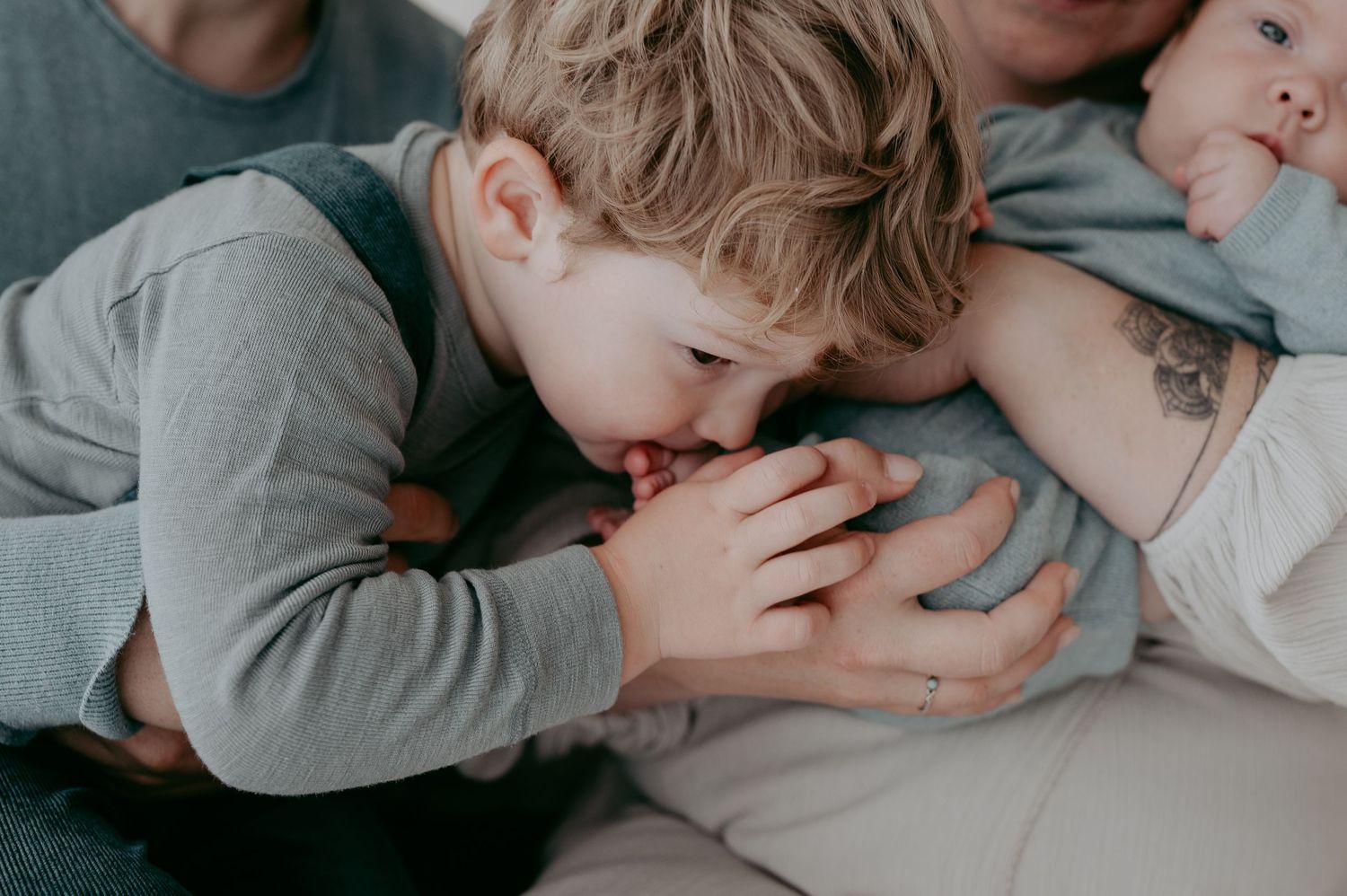 Intimate family moment with young child kissing a pregnant belly.