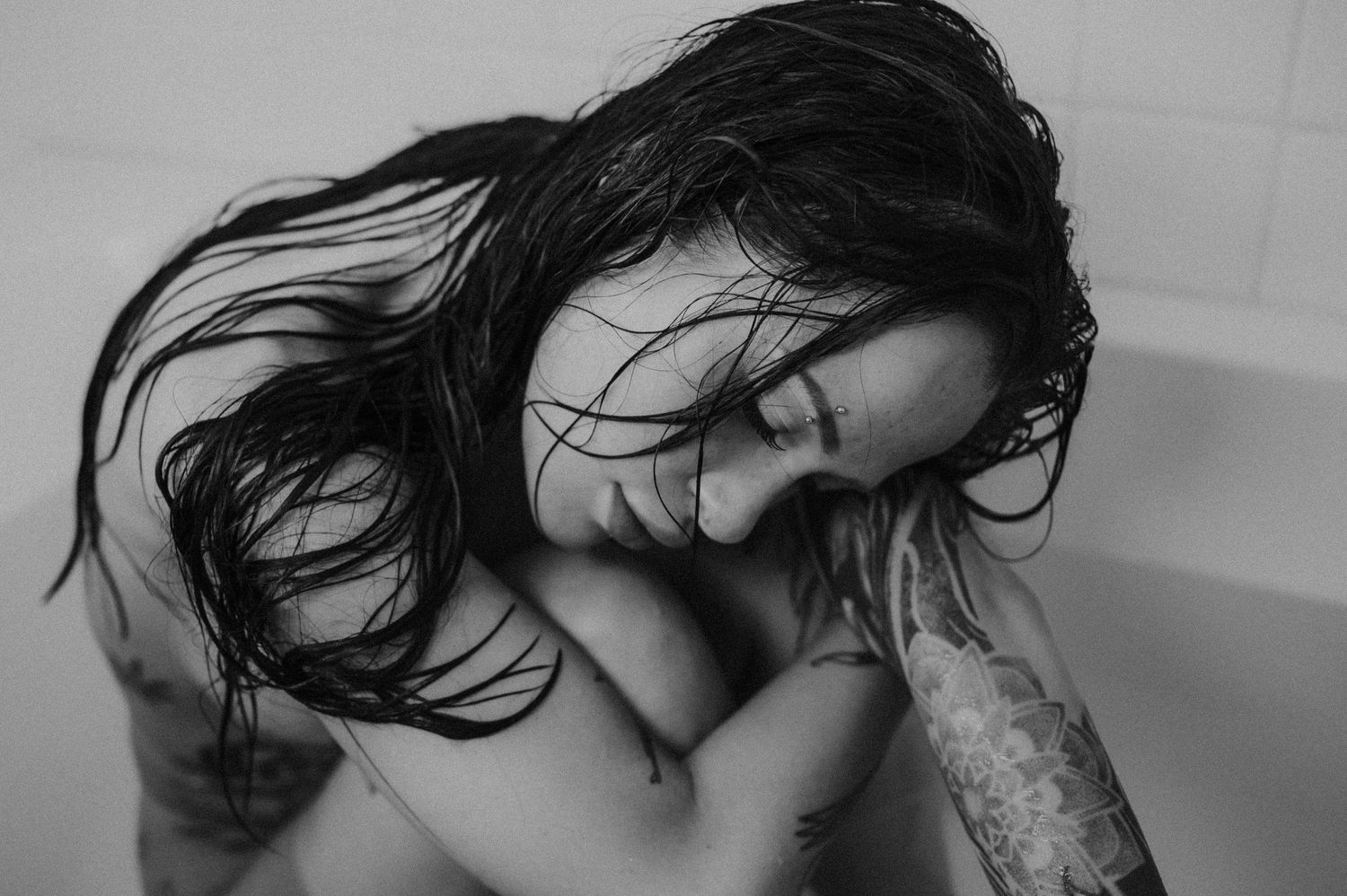 Dramatic black and white portrait of person with wet hair in emotional moment.