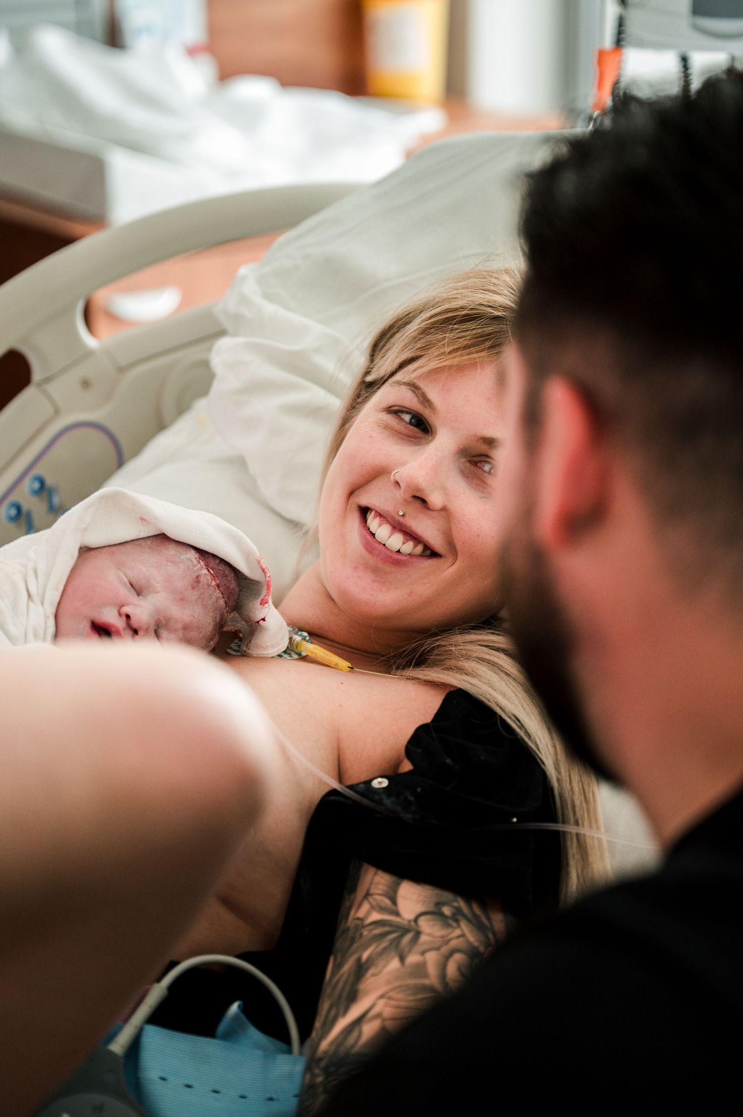 Candid hospital room scene showing emotional moments of affection between patient and visitor on bed.