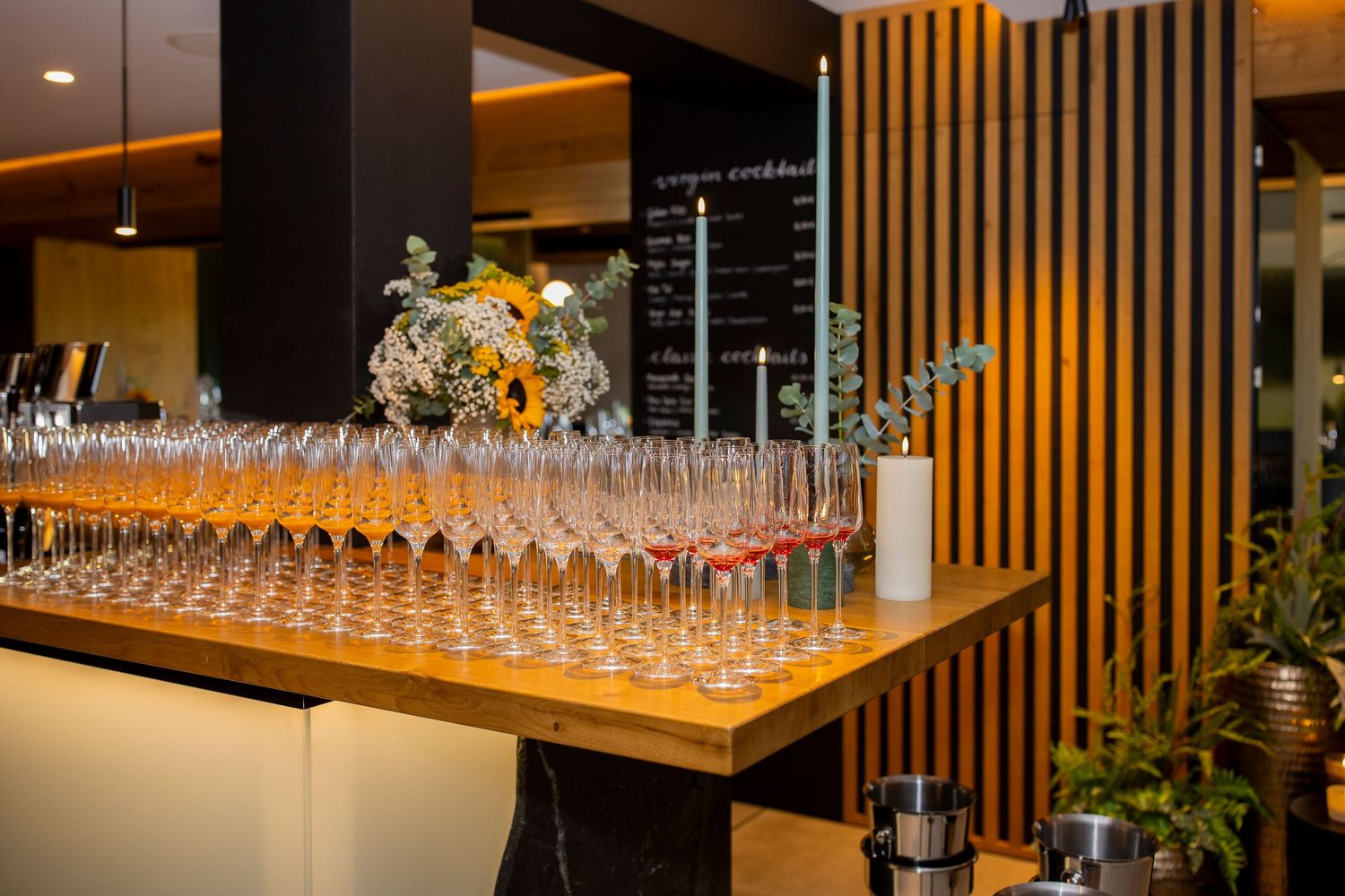 Aperitif für eine Veranstaltung aufgereiht auf dem Bartresen, in stimmungsvollem Licht.