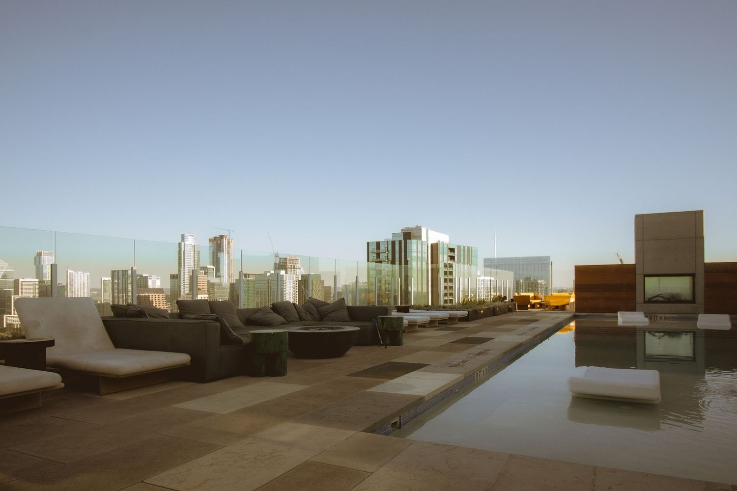 Moderne Architektur mit Pooldeck und Stadtlandschaft im Hintergrund.