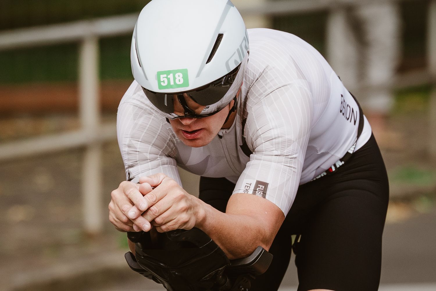 Triathlet in Aero-Position auf dem Fahrrad, nach unten blickend.