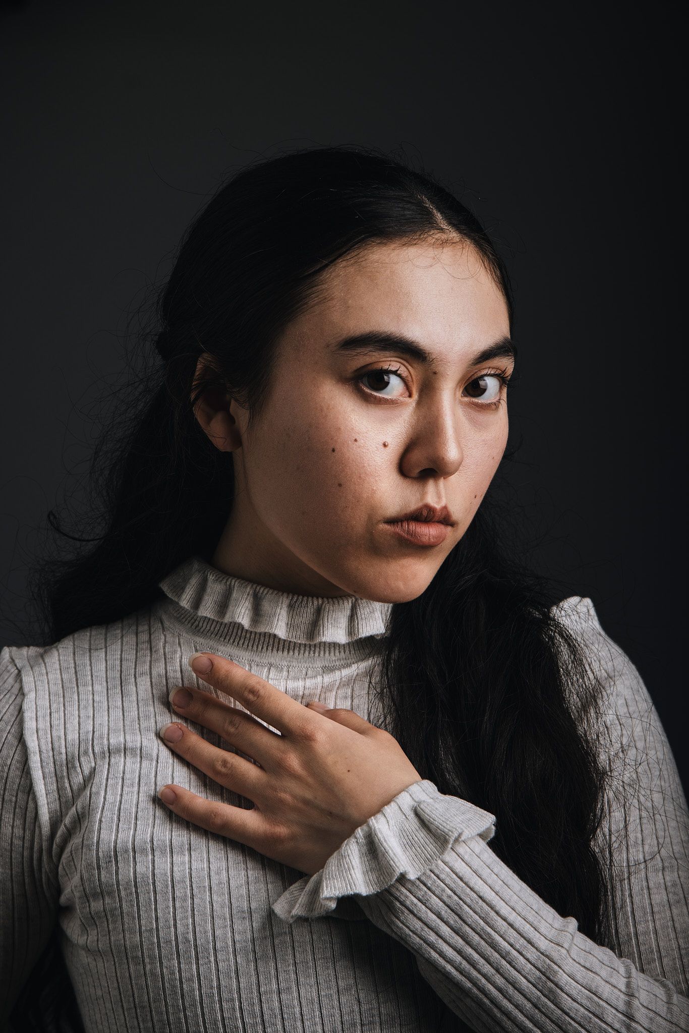 Editorial portrait of woman in white turtleneck sweater showing contemplative expressions.