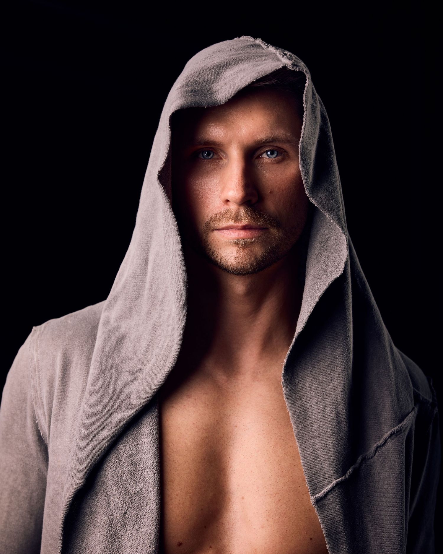 Dramatic portrait series showing a hooded figure in grey against dark background.