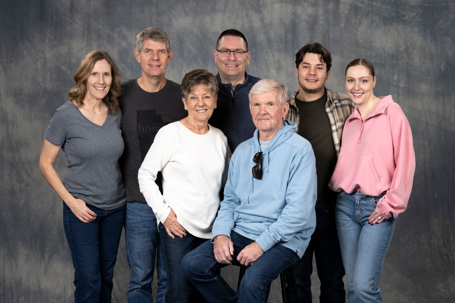 Multi-panel professional family portrait series against a textured gray backdrop showing different poses and groupings.
