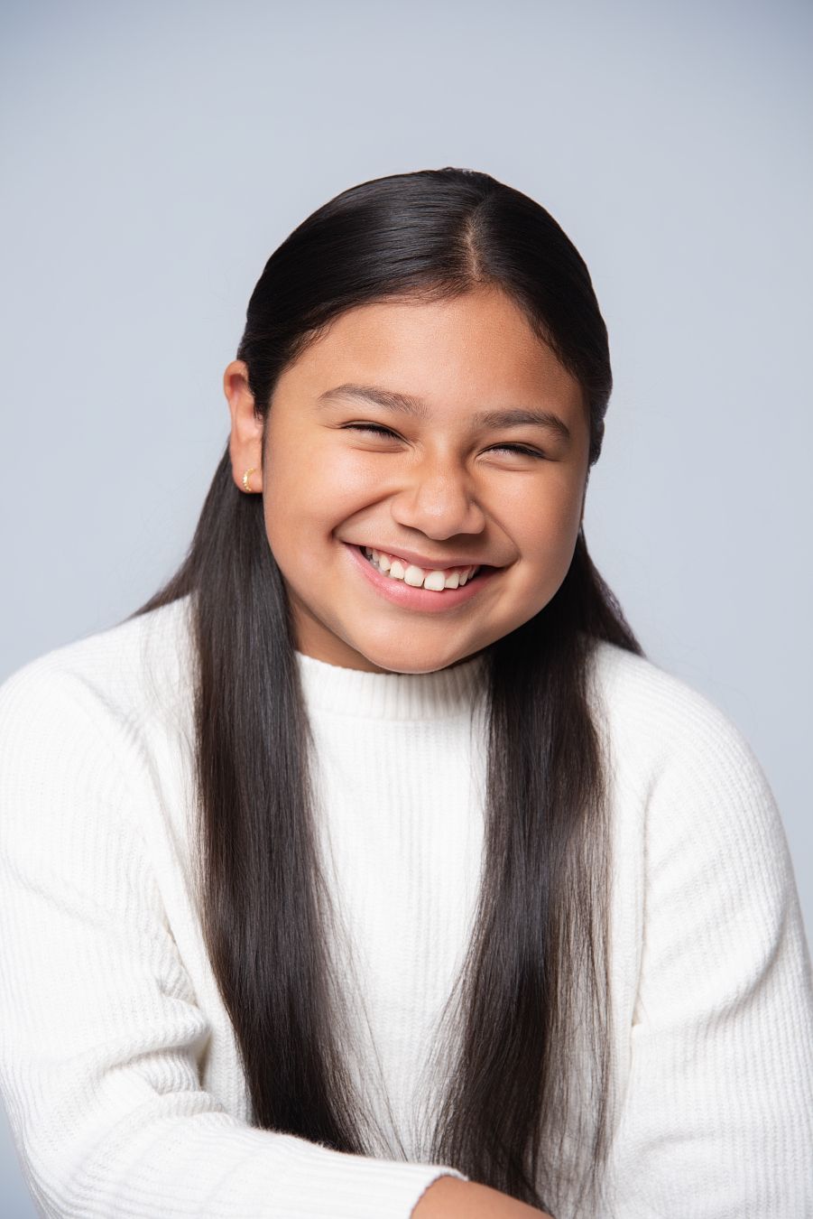 A series of four candid shots showing someone in a white sweater with long dark hair expressing joyful emotions.