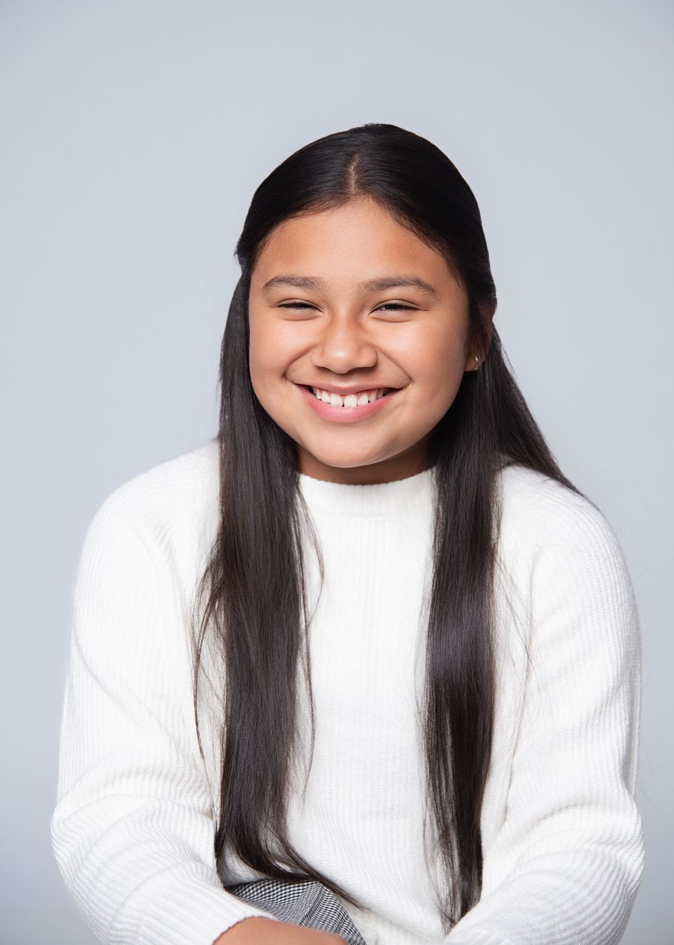 A series of four headshots showing someone in a white sweater with long dark hair expressing different emotions.
