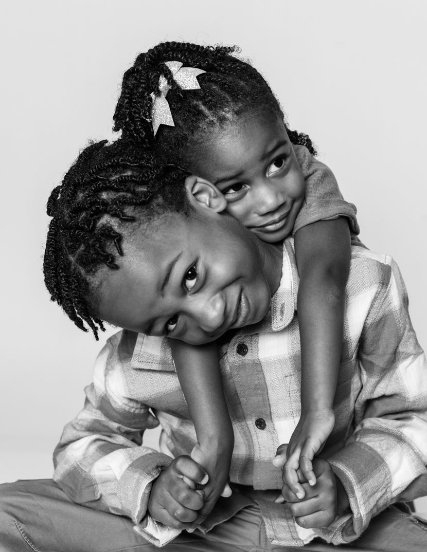 Black and white photos capturing playful poses in casual attire.