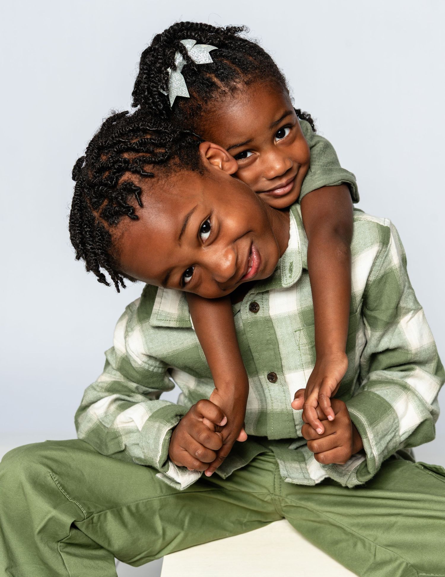 Playful poses of a child wearing a green plaid outfit on a white background.