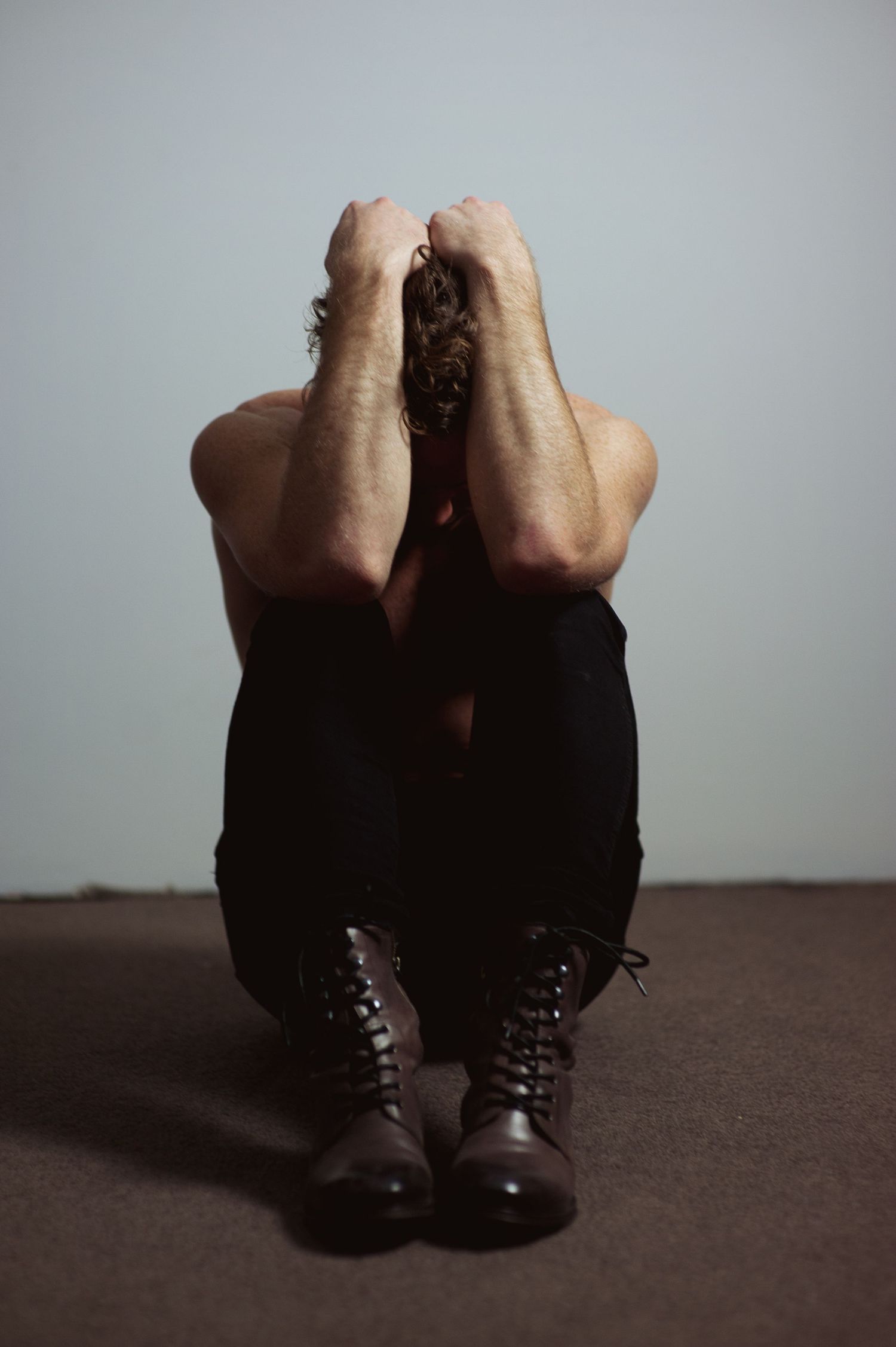 Multiple shots of brown leather boots on a dark surface with minimalist composition.
