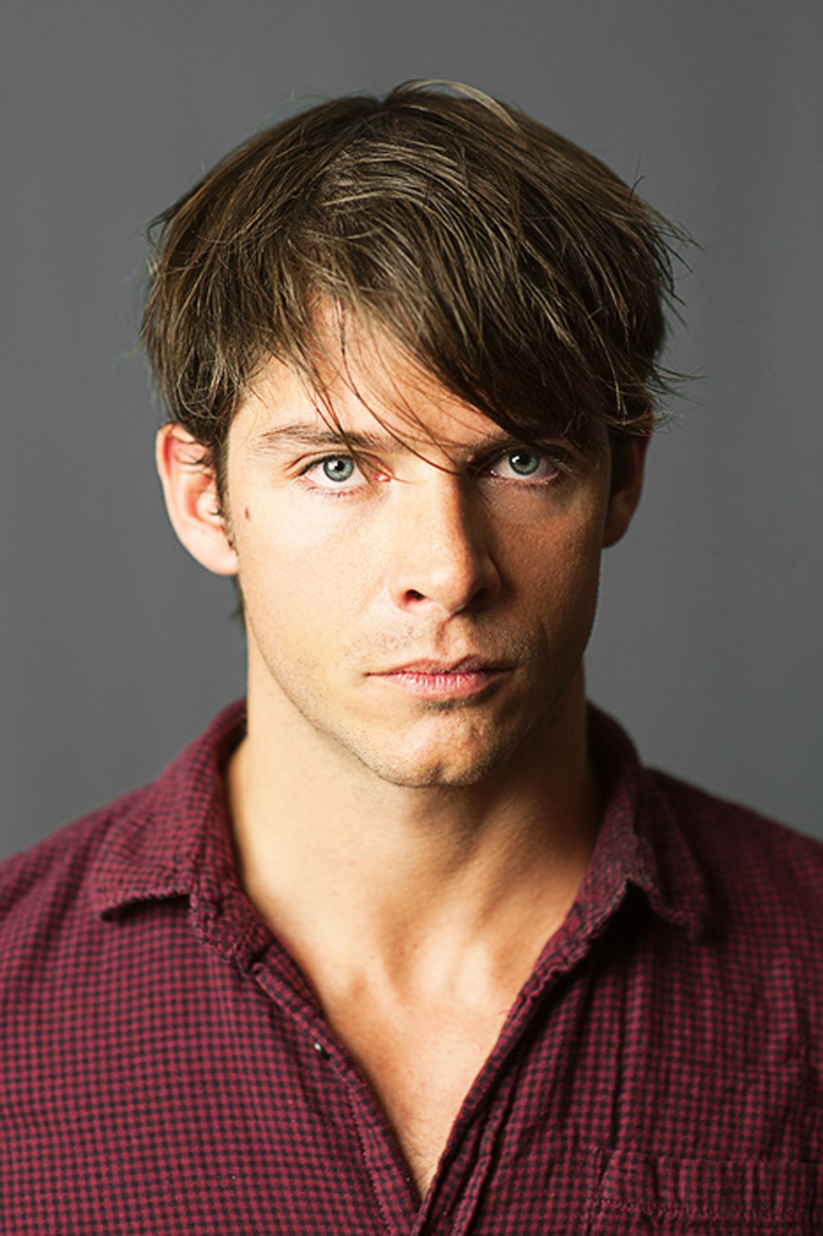 Portrait series of a person in a red checkered shirt with styled hair against a gray backdrop.