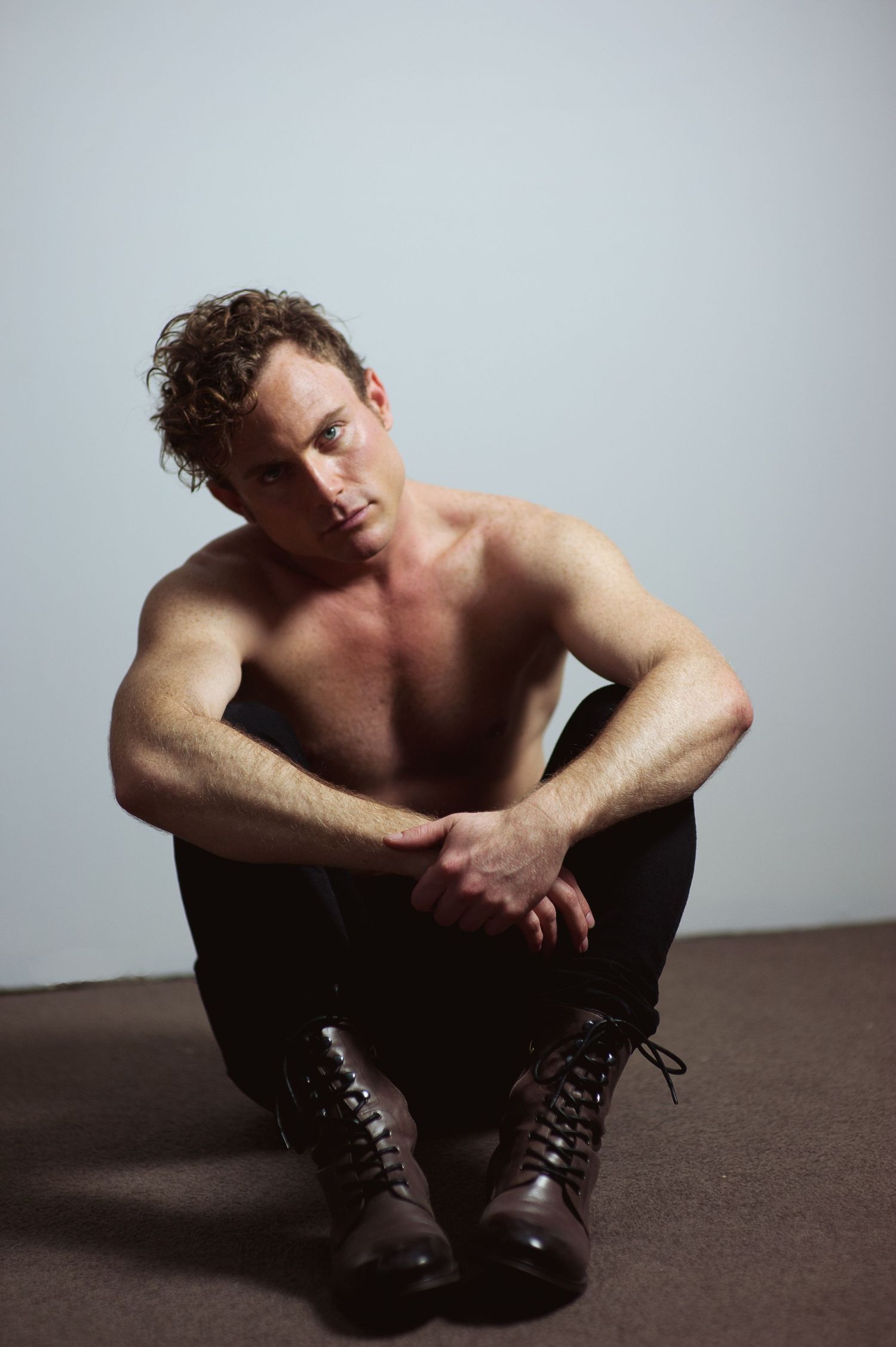 Artistic studio portraits showing a shirtless figure in dark pants against white background.