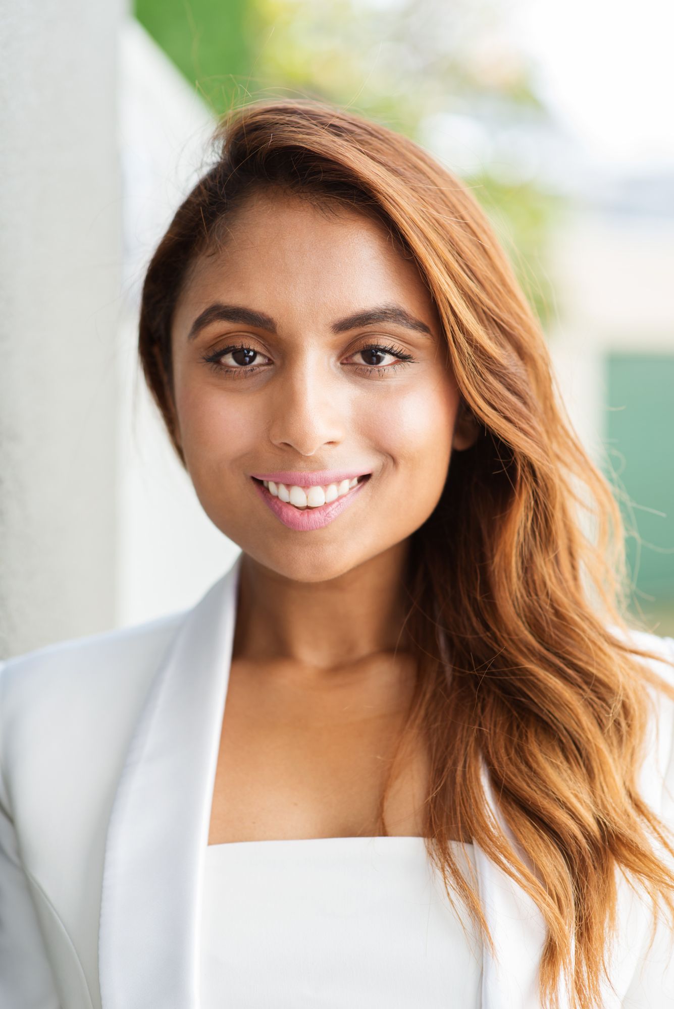Series of portraits showing a woman in white clothing with a bright smile and long wavy hair.