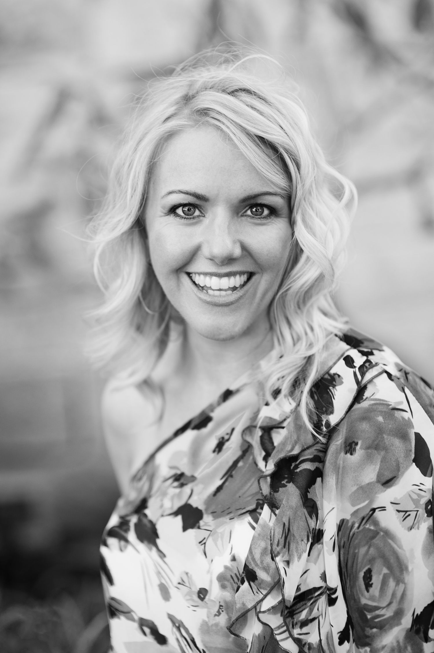 Black and white portraits of a woman in a floral print dress with light hair.