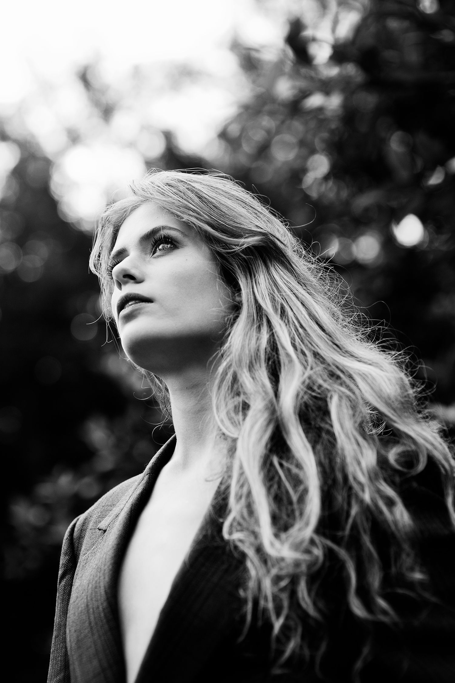 Dramatic black and white portraits with wind-swept hair against a bokeh background.