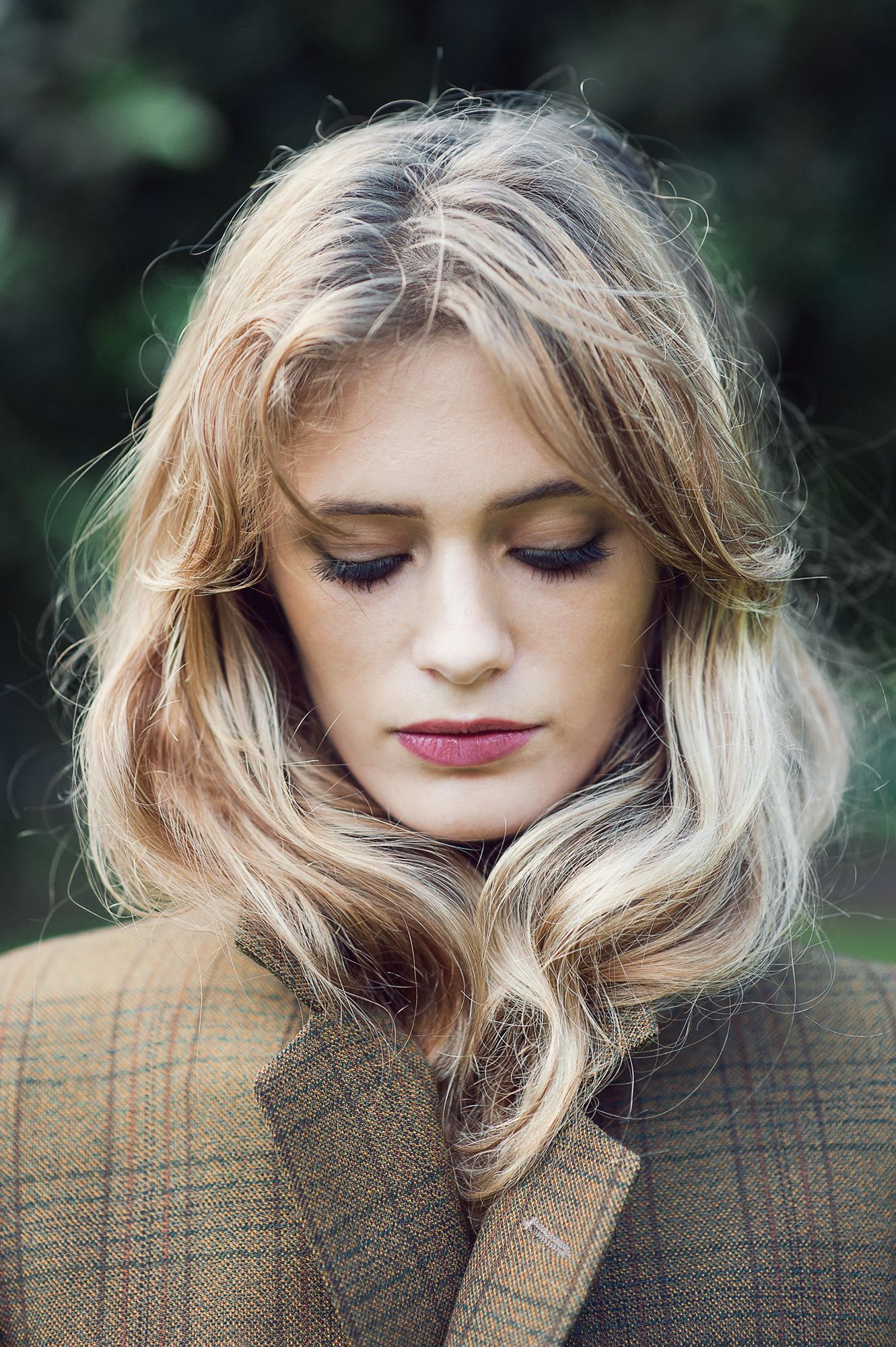 Soft portrait series featuring wavy blonde hair and subtle makeup against an earthy background.