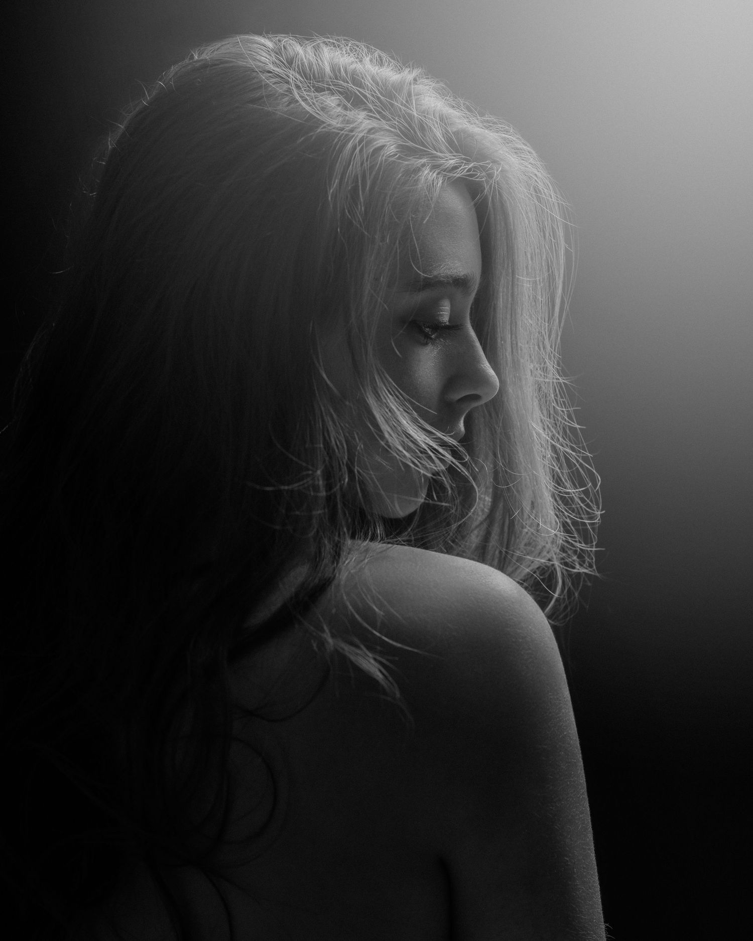 Dramatic black and white boudoir series with moody lighting.