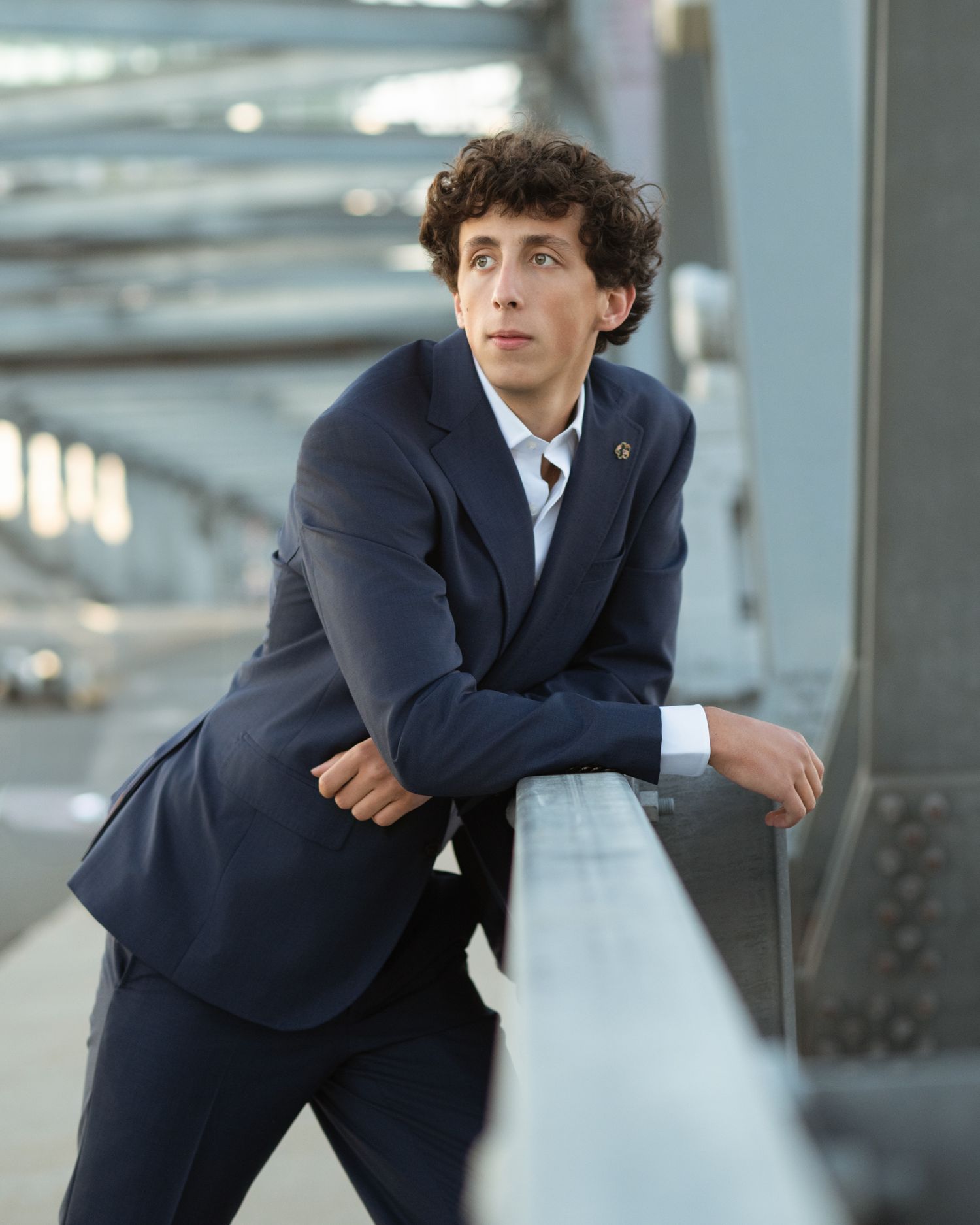 Young person in business suit posing dynamically in modern office setting.