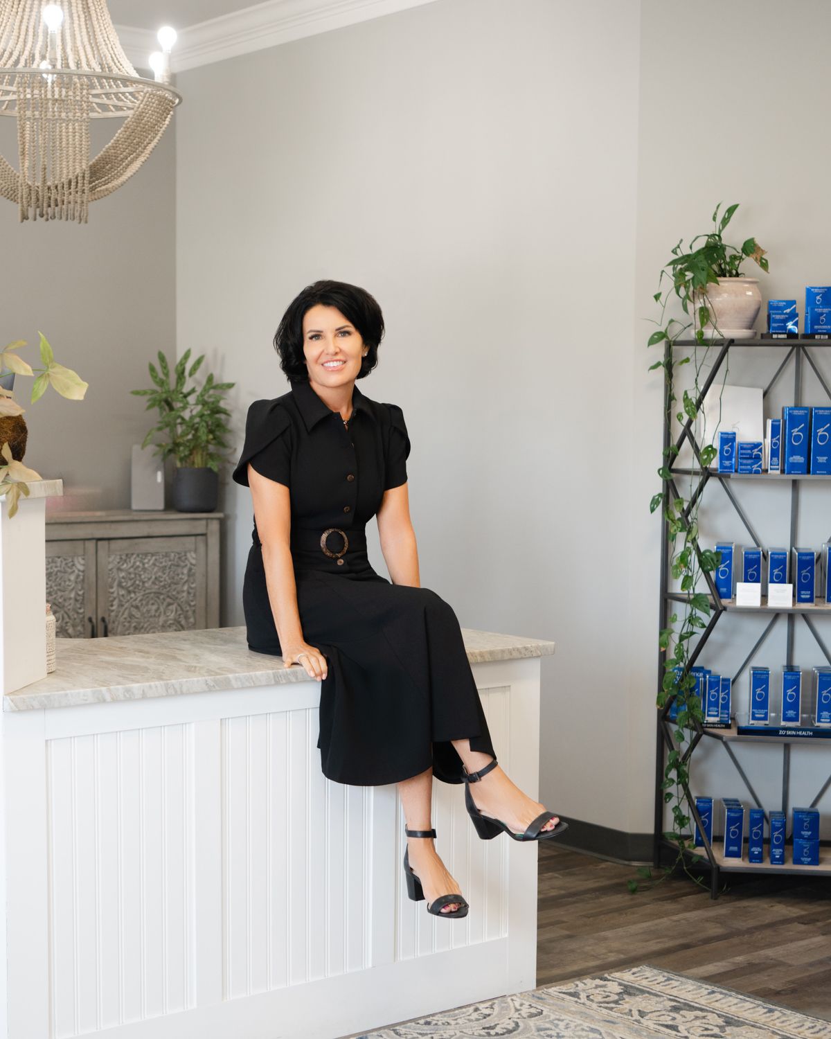 Woman in a medi spa in North Hampton NH with blue bottles displayed in background.