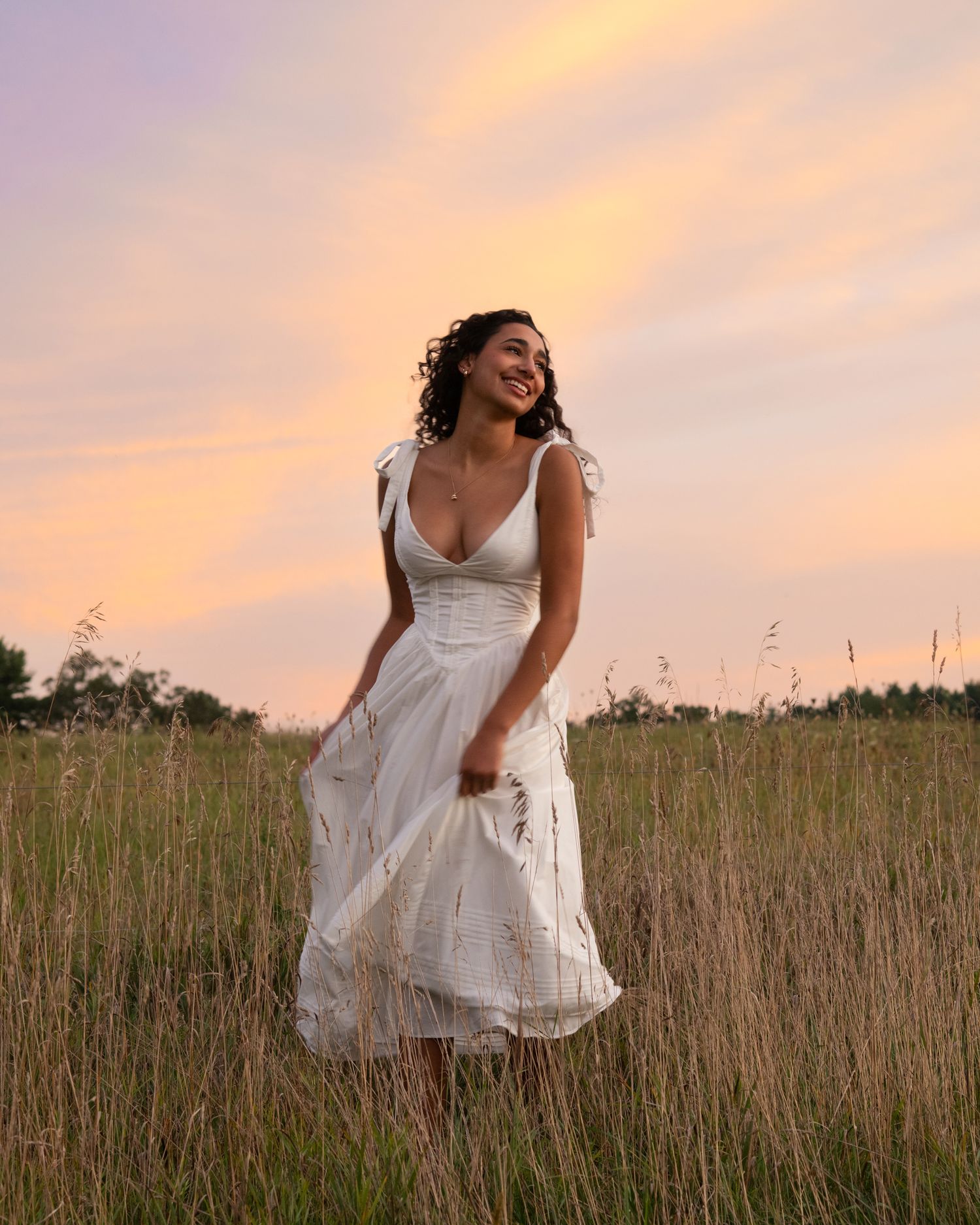 Artistic portraits in a field of tall grass during golden hour sunset.