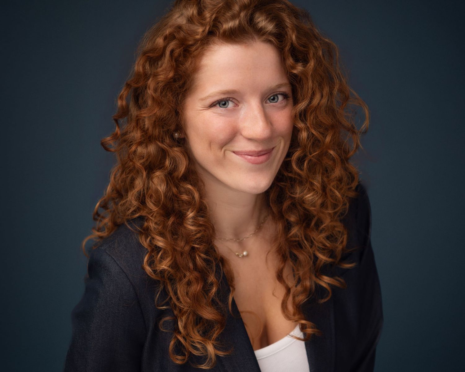 Professional headshot series featuring curly red hair against dark background.