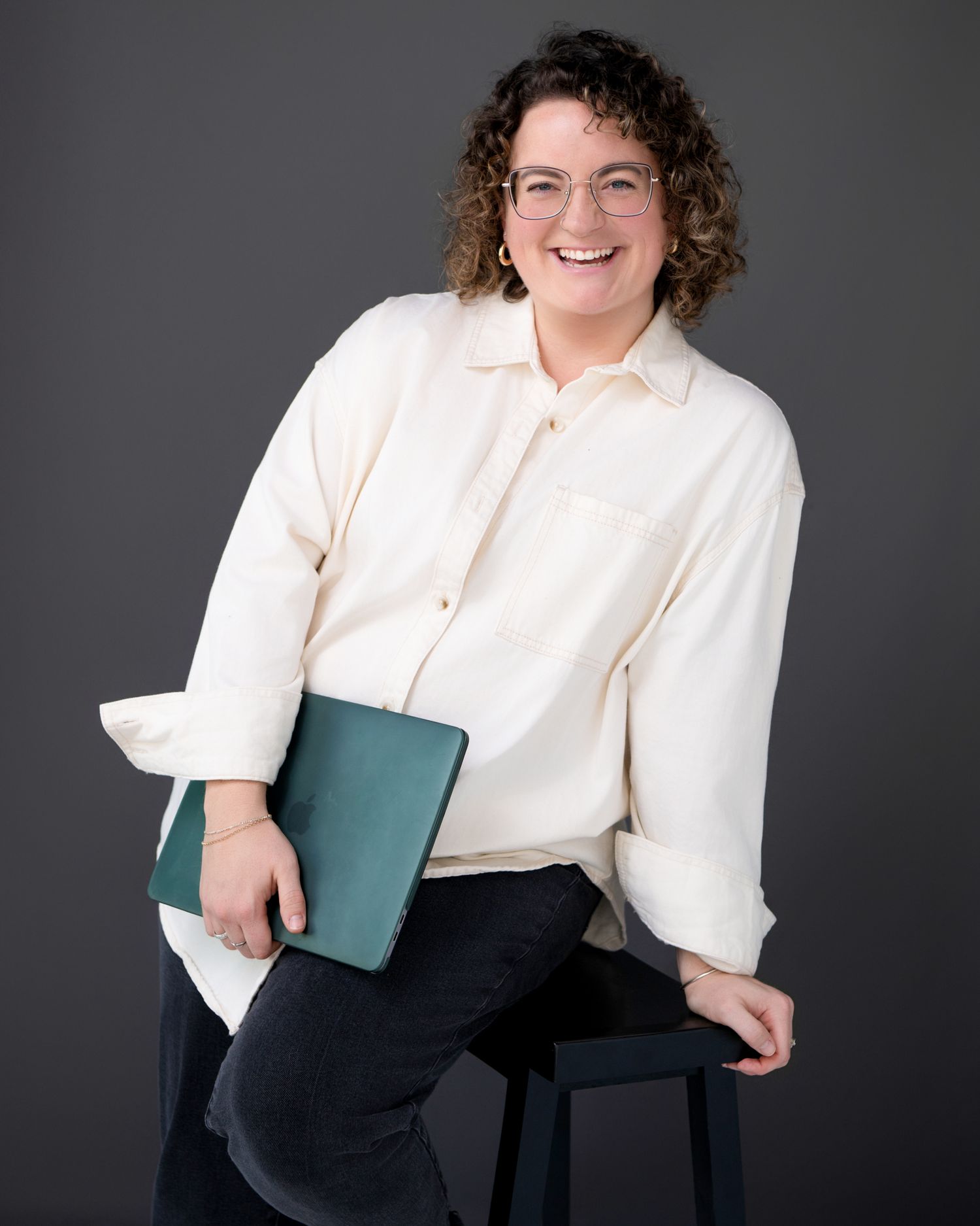 Professional portrait series in white blouse and dark bottom against gray background.