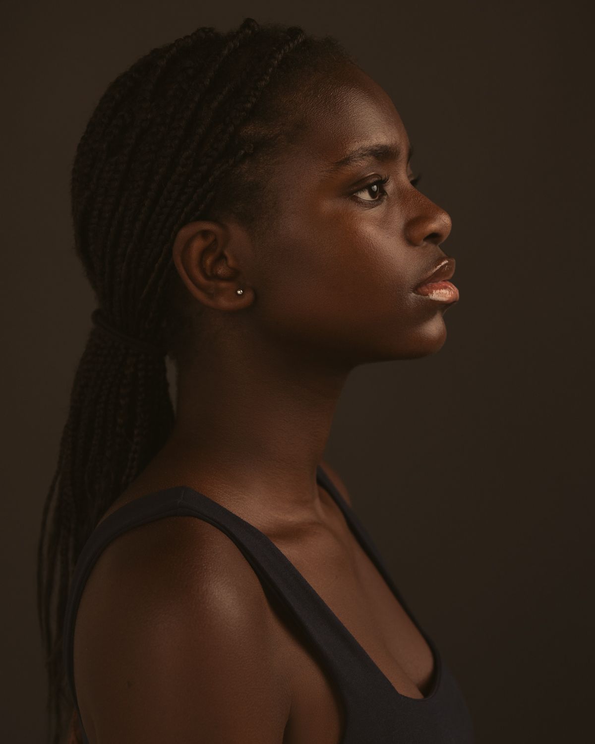 Artistic portrait series showing different angles and expressions in dramatic dark lighting.