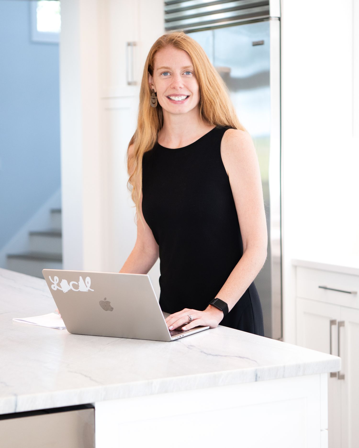 Professional photos of a person working on laptop in bright modern office setting.