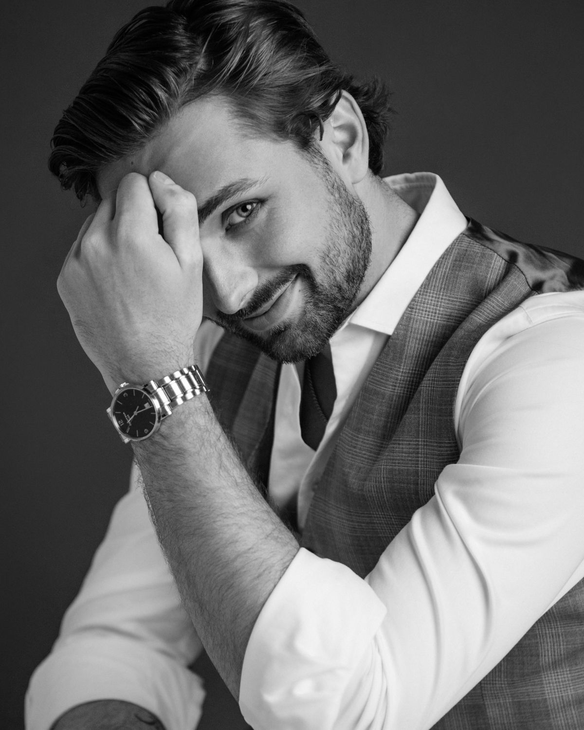 Professional male model in business attire against dark background.