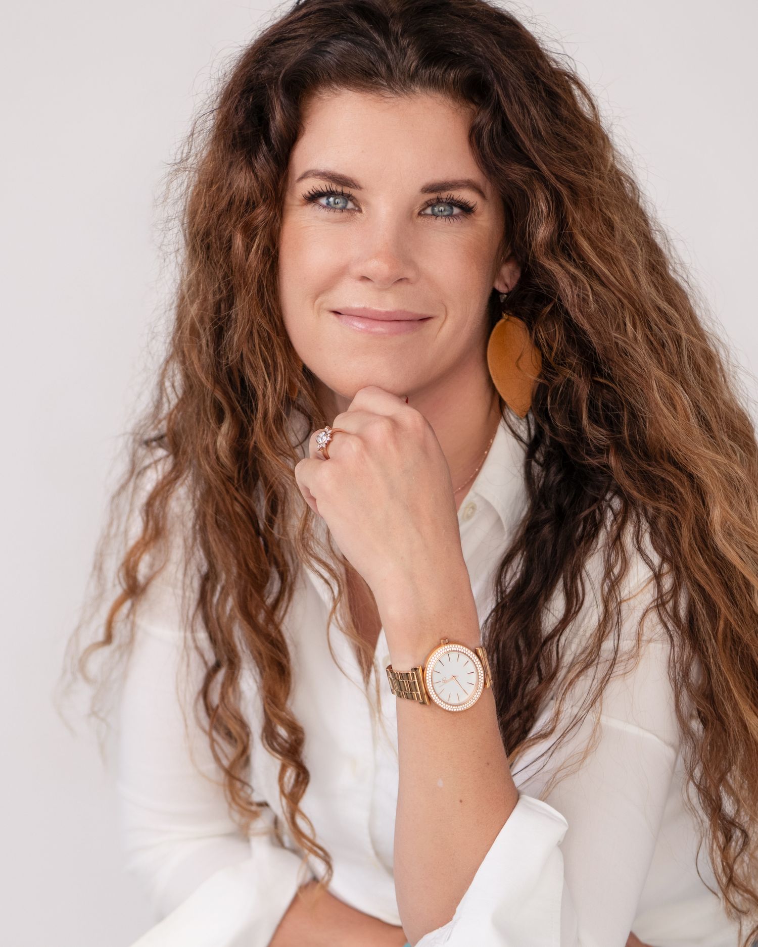 Studio portraits in white blouse showing various expressions and poses against white background.