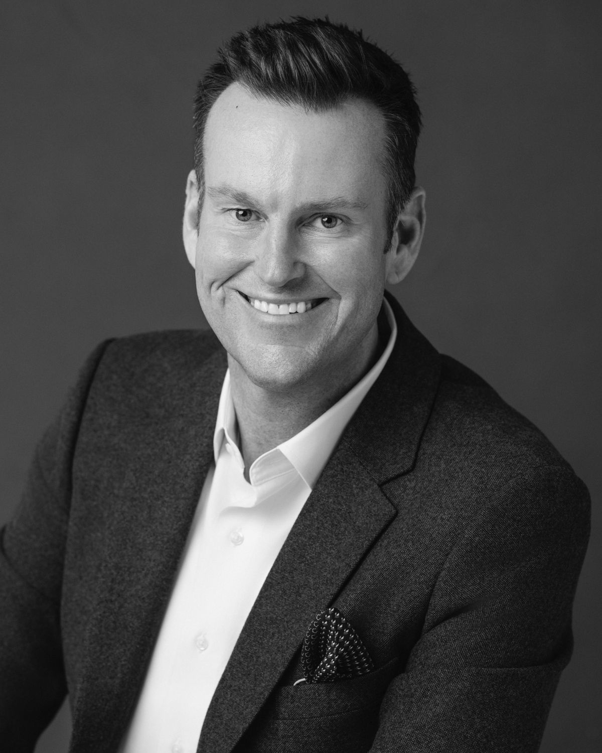 Professional black and white headshot series showing confident expressions against dark background.