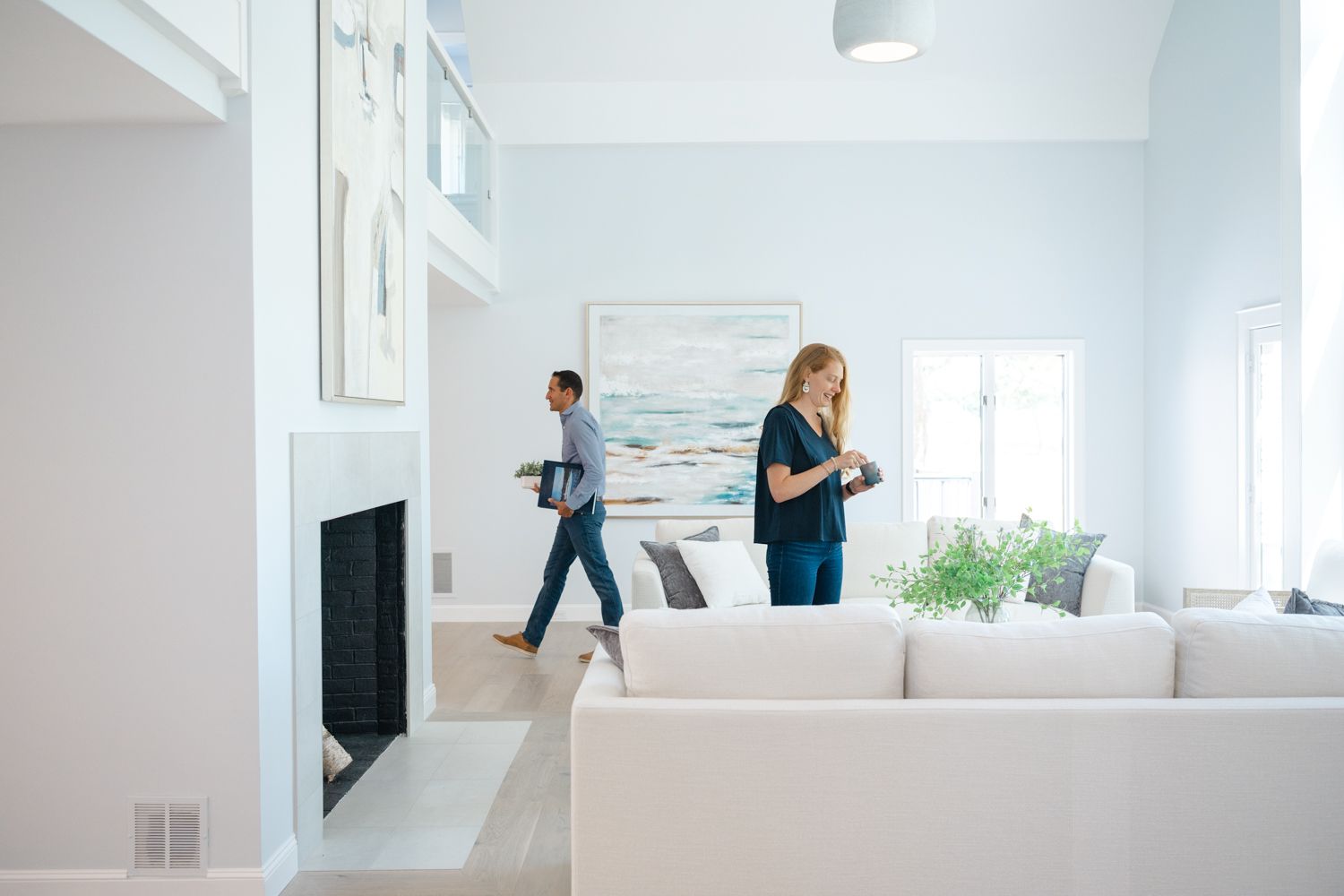 Couple moving boxes and furniture in bright white modern apartment with minimalist interior design Realtor Branding Seacoast NH