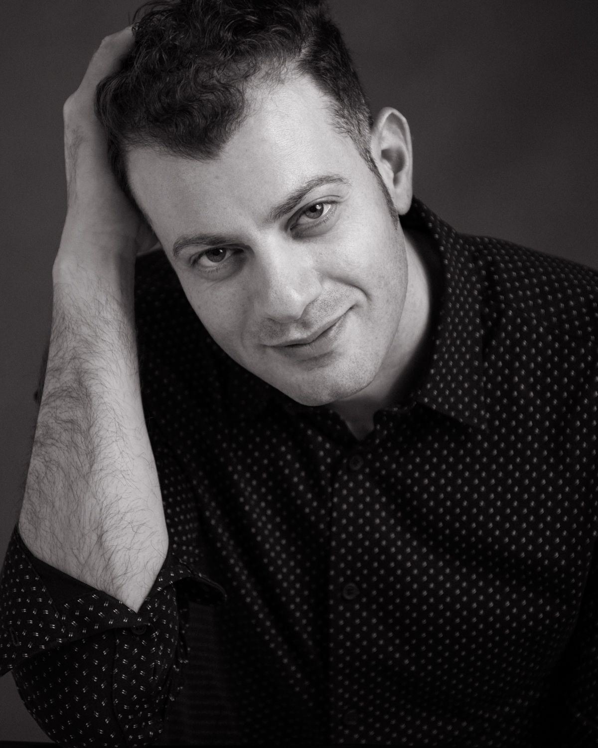 Black and white headshots in polka dot shirt with casual poses.