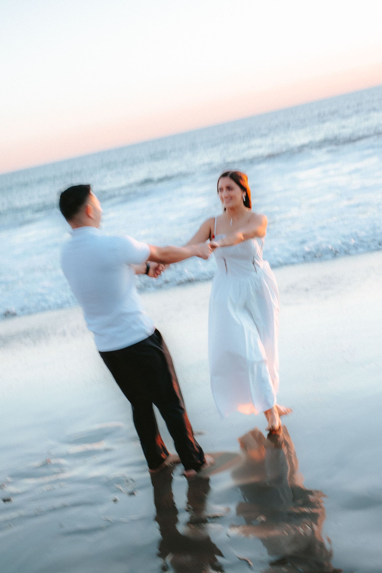 Couples spinning and laughing on the beach, celebrating love in a playful, cinematic, and timeless style.