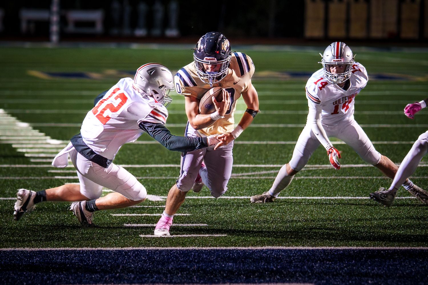 Football players diving and tackling during an intense game play.