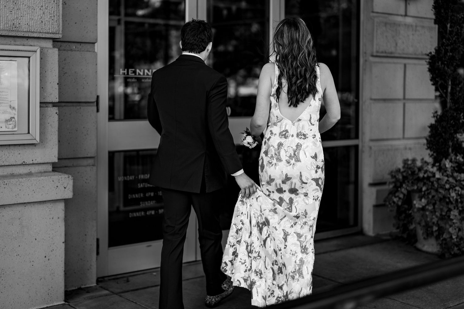 Couple strolling past storefronts in black and white photography.
