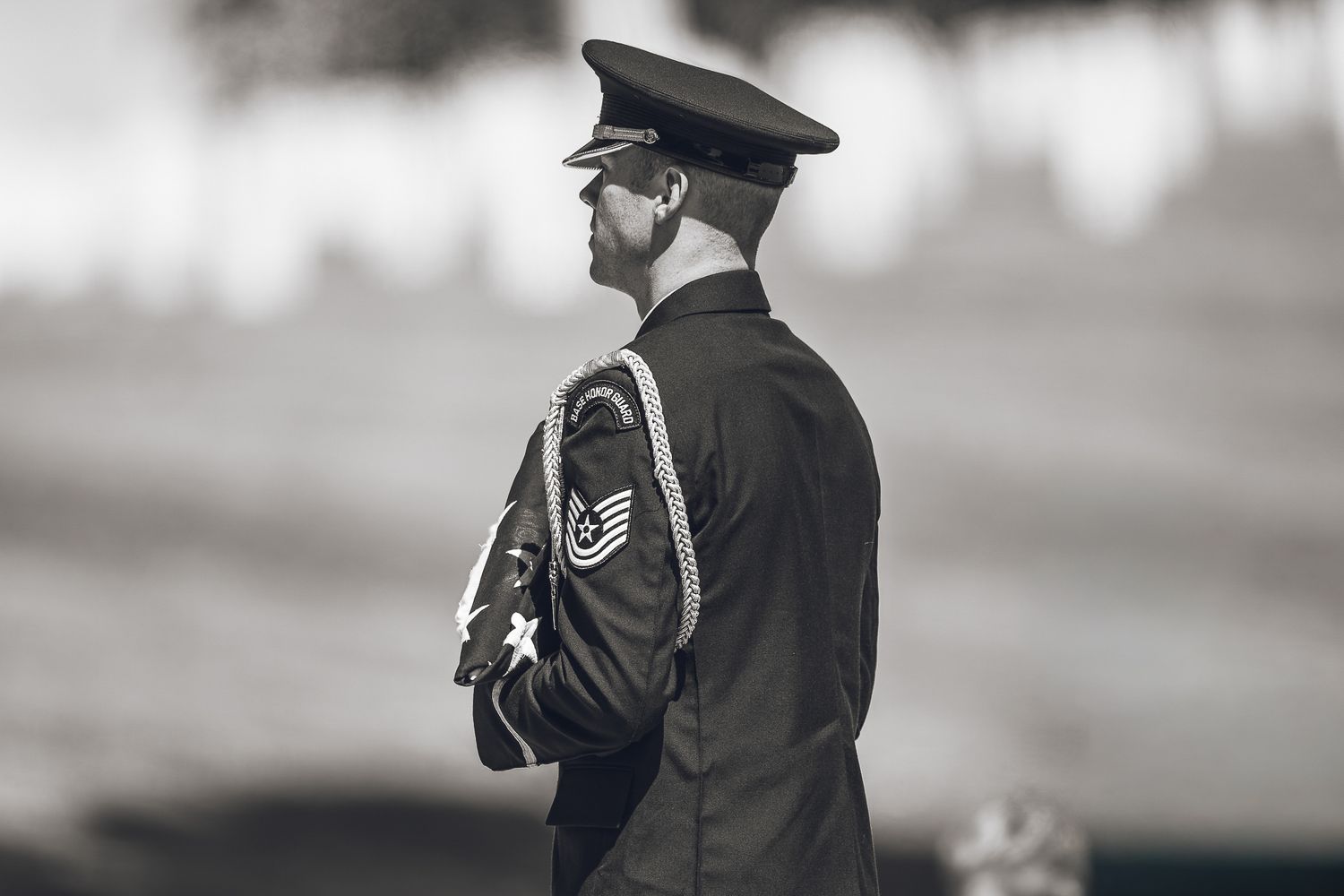 Black and white photo of a US Air Force staff sergeant in dress uniform standing at attention outdoors.