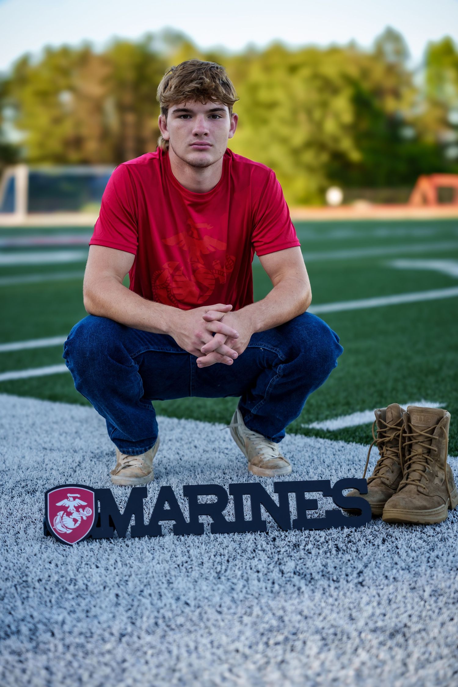 Marines recruitment display on football field sideline with combat boots.