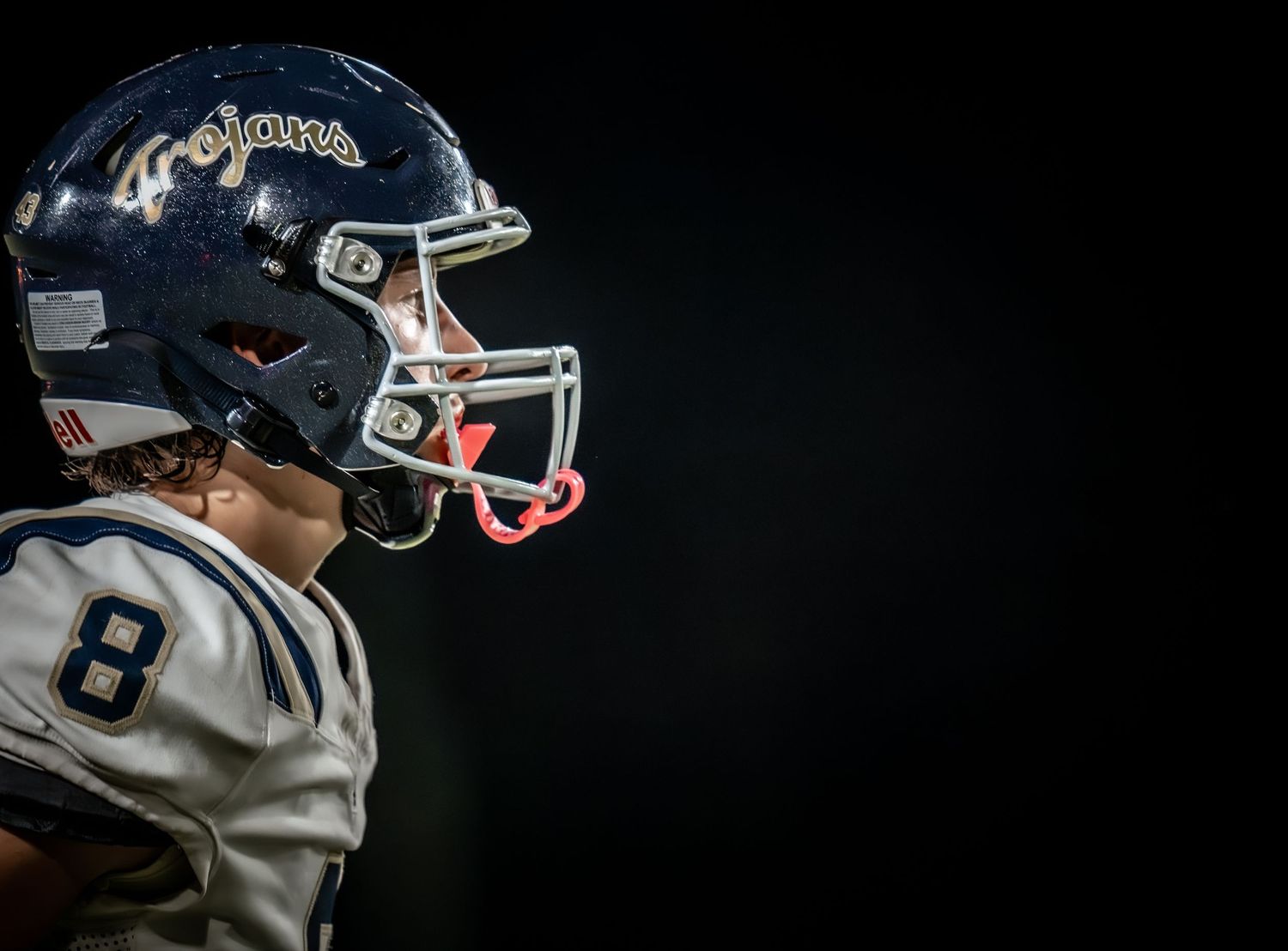 Close-up detail of football helmet against dark background.