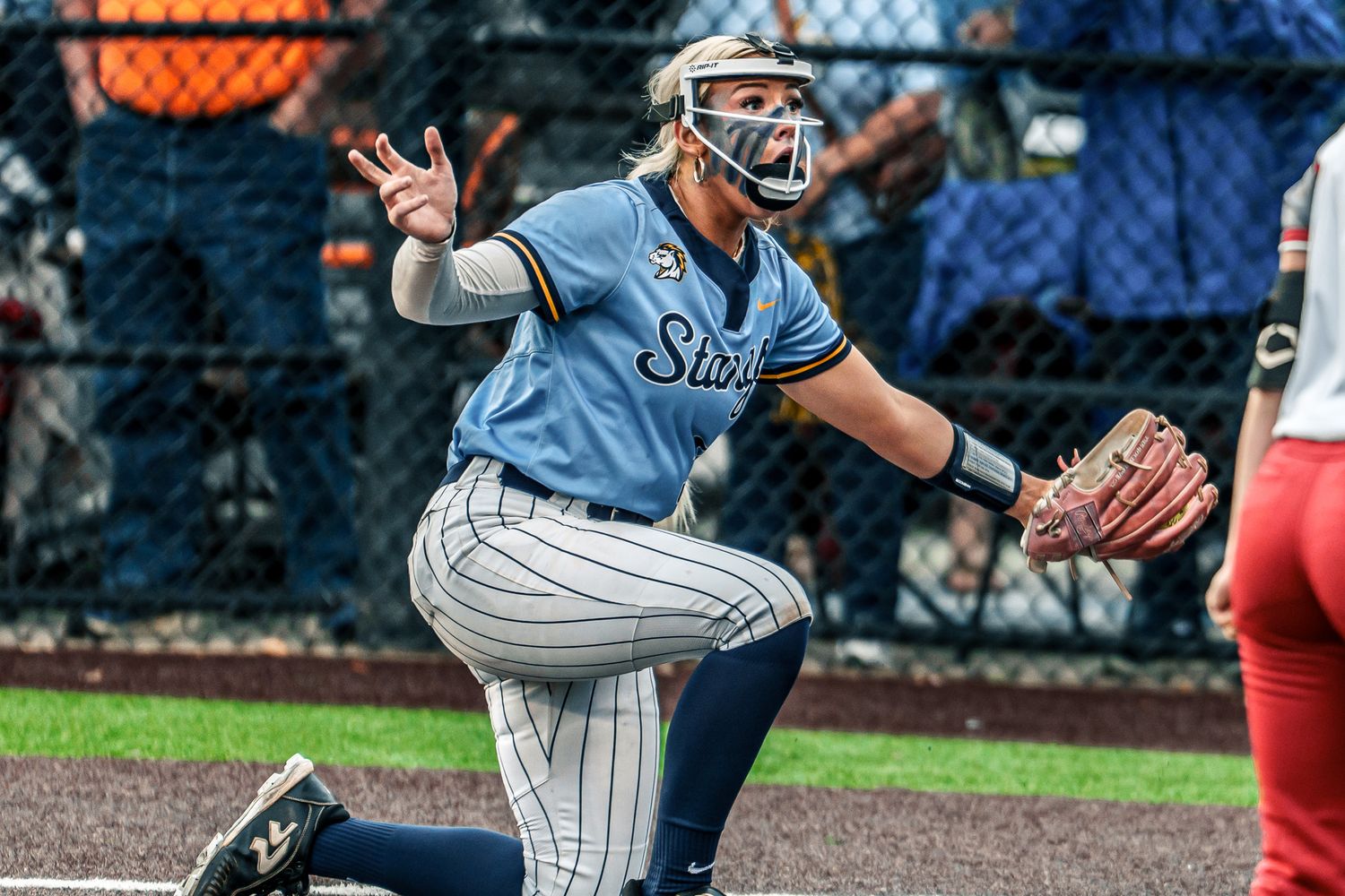 Baseball players in action during a competitive game with dramatic lighting.